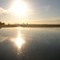 Sol reflejado en laguna de zona rural / Lautaro