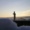 Friedhofkruzifix vor aufgehender Sonne im Neuschnee