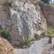 Quarried granite rock face above water filled pit. Note dark grey pseudotachylitic brecchi in granite