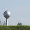 Silver water tower of Tenneco Automotive viewed through I-94