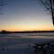 Scenic view of frozen Maple Lake at sunset