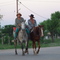 dos gauchos a caballo en un suburbio de Resistencia