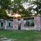 the summer sun sets through the trees behinds a cinder block shell of a roadside building in Ridgeway, NC, 7-27-11
