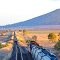 Boggabri, Nth West NSW. A grain train, No. 5456, is waiting in the loop for the Moree Xplorer passenger train, no. NP43, to pass. Bathed in late golden sunshine, Mt. Binalong rises to 496m in the right distance. June 2011.