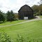 a black bear to the left of the barn