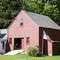 Red barn and white house, proudly flying the American Flag.