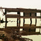 An old jetty reflected in a salt pool