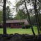 Rock wall and red house with black trim.