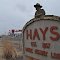 sign on north Vine with Watching the Wagons Come In, sculpture by   Pete Felten, Hays, KS